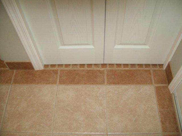 Photo of floor tile transition under a bifold door.
