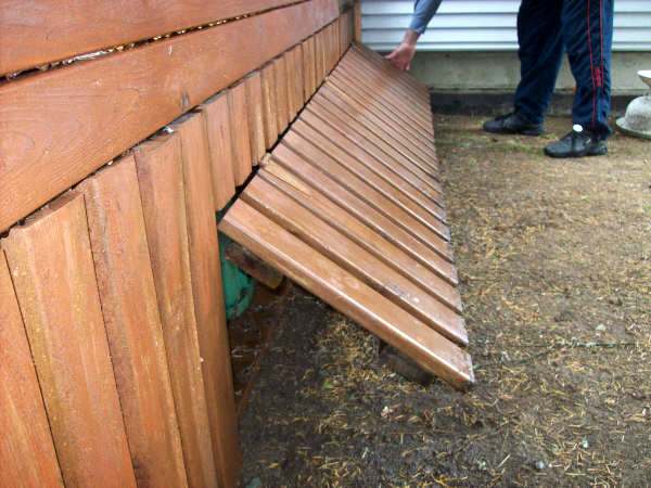 Photo of the open gate into the storage area under the backyard wood deck.