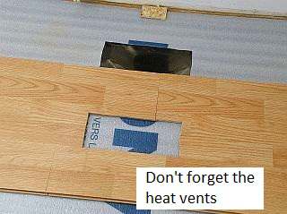 Photo showing floor vents in a laminate floor.