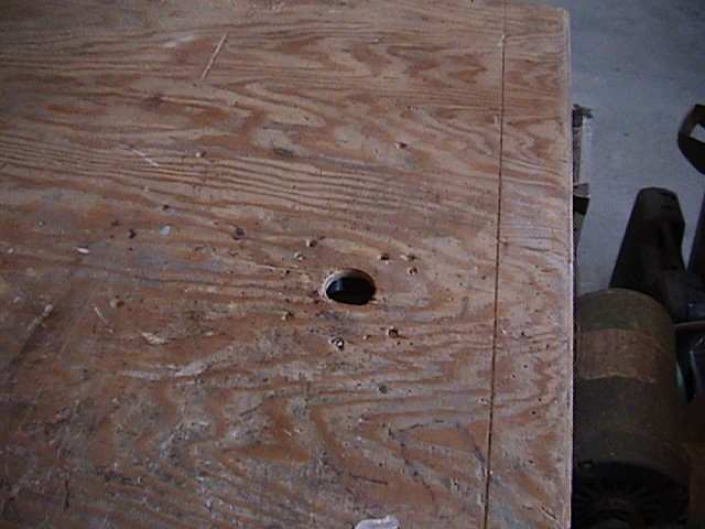 Photo of a close-up of the hole in a router table for the router bit.